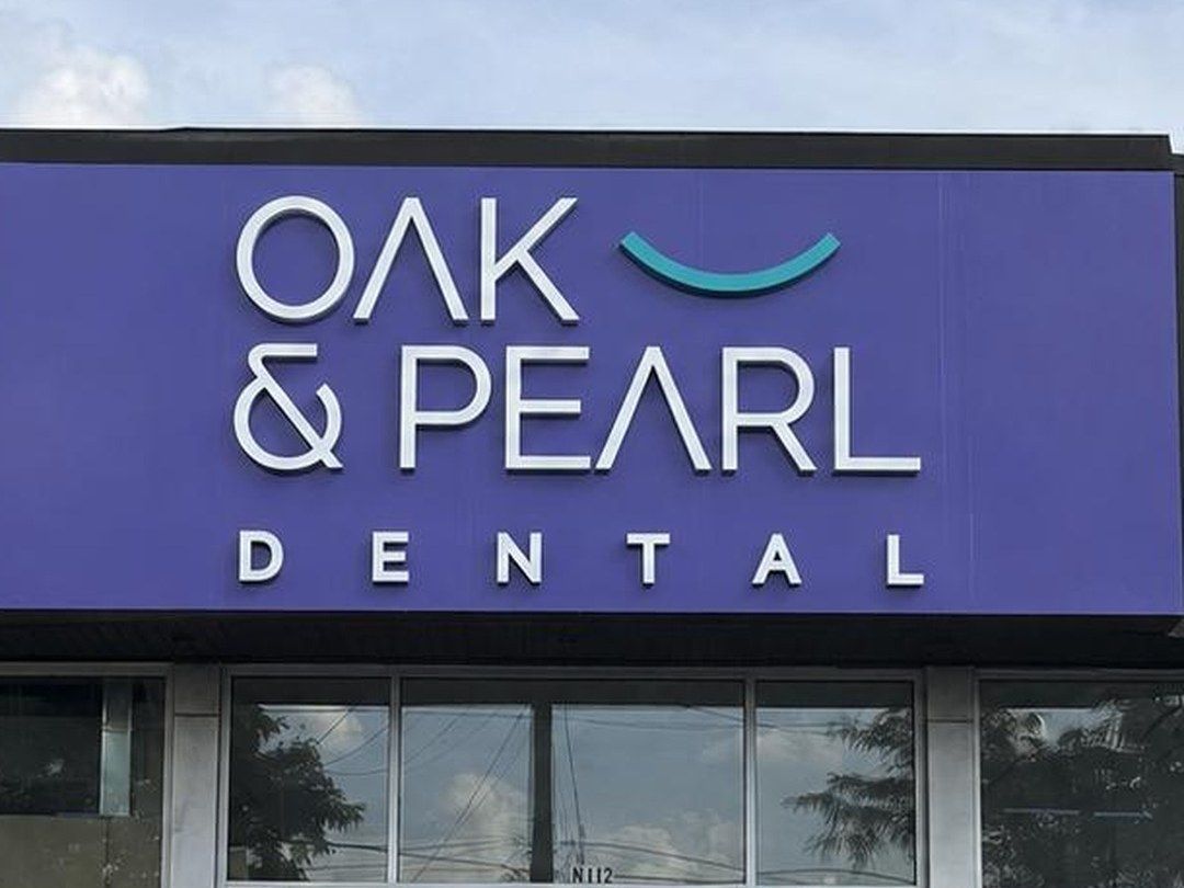 The purple Oak & Pearl Dental sign above the clinic entrance on Sportsworld Drive